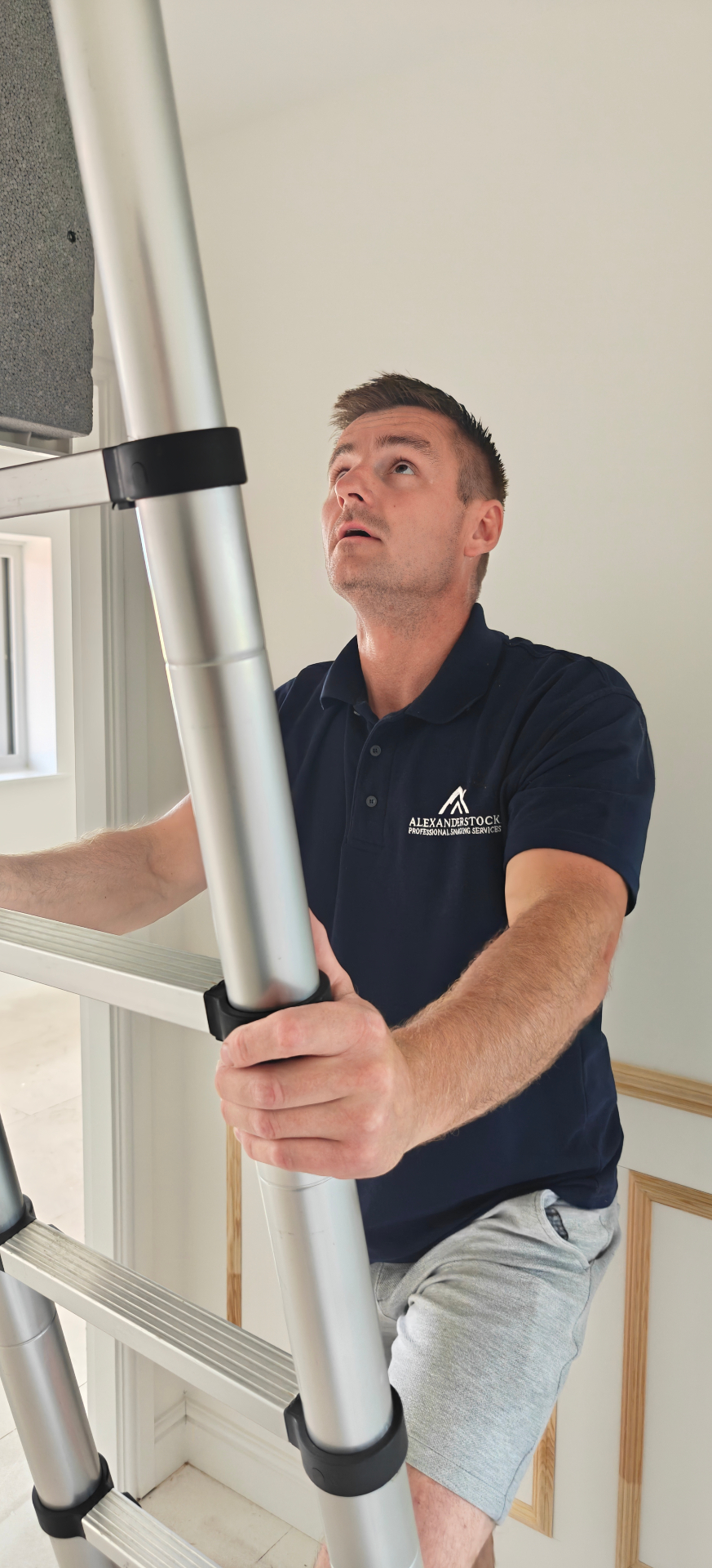 Gareth inspecting a loft hatch on site, wearing his AS Pro Snag branded shirt